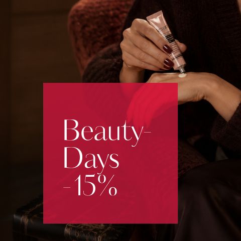 Eine Person cremt sich die Hand ein, neben ihr steht eine rote Schachtel mit der Aufschrift: „Beauty-Sale – 15 %“.