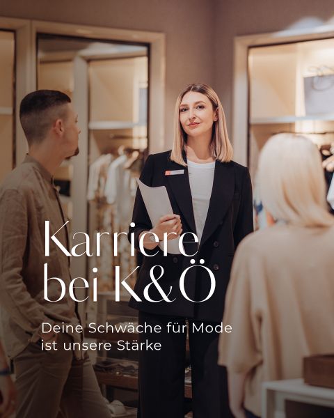Eine gut gekleidete Frau steht selbstbewusst in einem Bekleidungsgeschäft und spricht mit zwei Kunden. Der Text lautet auf Deutsch: "Karriere bei K&Ö. Deine Schwäche für Mode ist unsere Stärke.